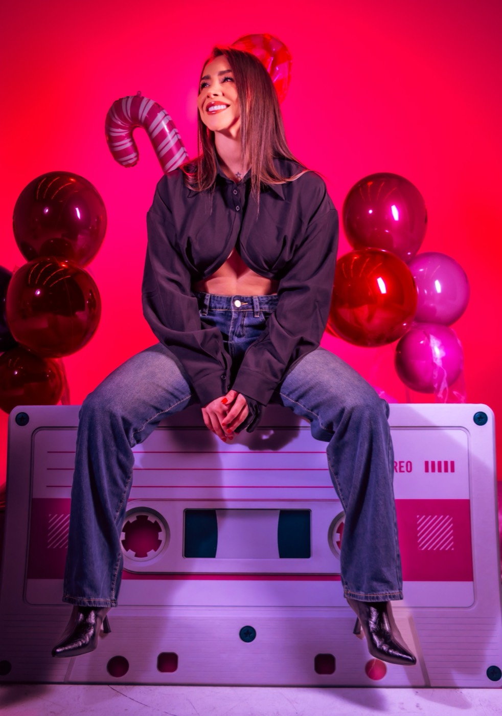 Nana sonriendo sentada sobre un cassette gigante