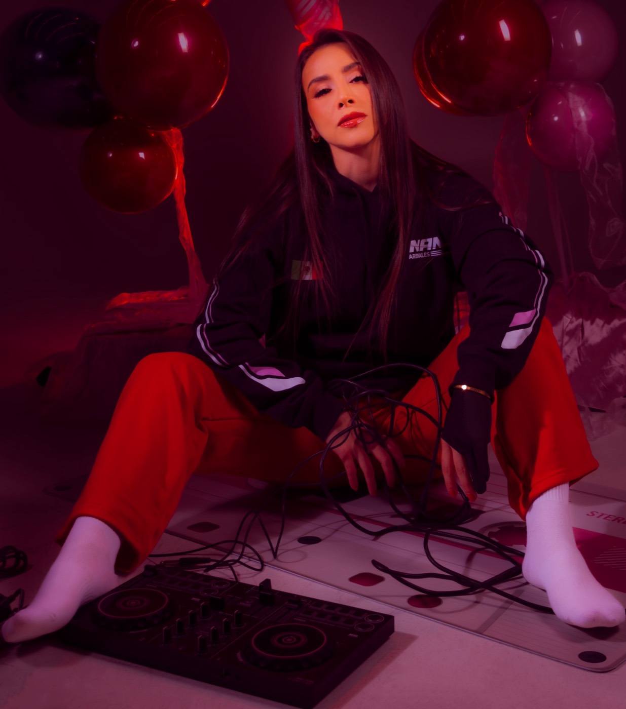 Nana sentada con su controlador de DJ y cables
